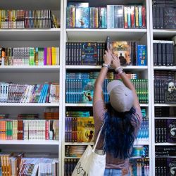 Una mujer coloca un libro en una repisa de un estand durante la 47 Feria Internacional del Libro de Buenos Aires en el predio ferial La Rural. | Foto:Xinhua/Martín Zabala
