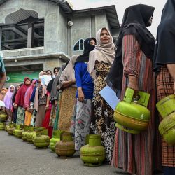 Personas hacen cola con garrafas de gas para comprar Gas Licuado de Petróleo (GLP) subvencionado para cocinar en un centro de distribución en Lambaro, provincia indonesia de Aceh, Indonesia. | Foto:CHAIDEER MAHYUDDIN / AFP