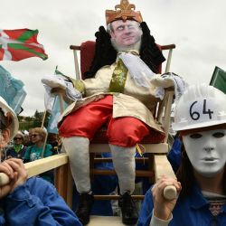 Manifestantes enmascarados portan un muñeco que representa al presidente francés mientras participan en una manifestación a más de un mes de que el gobierno sacara adelante en el Parlamento una impopular ley de reforma de las pensiones, en Bayona, sur de Francia. | Foto:GAIZKA IROZ / AFP