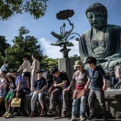 Un grupo de personas visita la estatua del Gran Buda en el templo Kotoku-in de la ciudad de Kamakura, en la prefectura de Kanagawa, Japón. | Foto:YUICHI YAMAZAKI / AFP