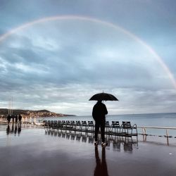 Un hombre observa un arco iris en el "Promenade des anglais" de la ciudad costera francesa de Niza, en el sur de Francia. | Foto:VALERY HACHE / AFP