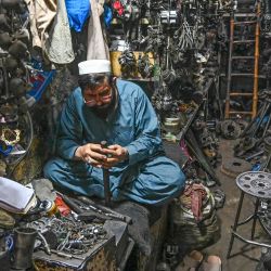 Un comerciante trabaja con piezas de repuesto de vehículos en el mercado de automóviles de Shoba Bazar, en la ciudad de Peshawar, en el noroeste de Pakistán. | Foto:ABDUL MAJEED / AFP