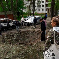 La gente examina un cráter cerca de edificios residenciales formado por restos de un dron ruso derribado en Kiev. Foto de SERGEI CHUZAVKOV / AFP | Foto:AFP