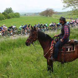 Personas a caballo observan a los corredores durante la cuarta etapa del Giro de Italia 2023, 175 km entre Venosa y Lago Laceno. | Foto:Luca Bettini / AFP