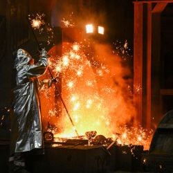 Un empleado toma una muestra en el alto horno 8 durante la visita del presidente alemán a Thyssenkrupp Steel Europe sobre el tema "transformación industrial" en Duisburgo, oeste de Alemania. | Foto:INA FASSBENDER / AFP