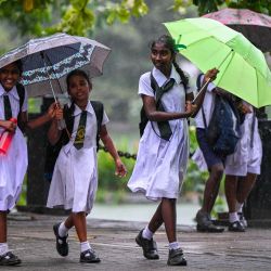 Unas escolares se cobijan bajo paraguas durante un fuerte aguacero en Colombo, Sri Lanka. | Foto:ISHARA S. KODIKARA / AFP