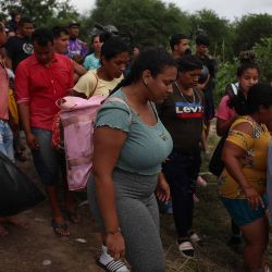 Los migrantes caminan hacia el Río Grande desde la orilla del río mientras cruzan para ingresar a los Estados Unidos en Matamoros, México. Foto de JOE RAEDLE/AFP. | Foto:AFP