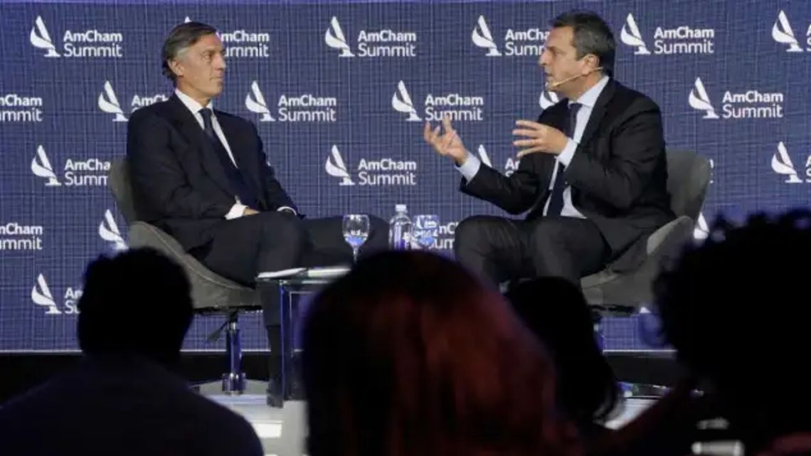 President of AmCham Facundo Gómez Minujín (L) speaks with Minister of Economy Sergio Massa (R) at the AmCham summit.