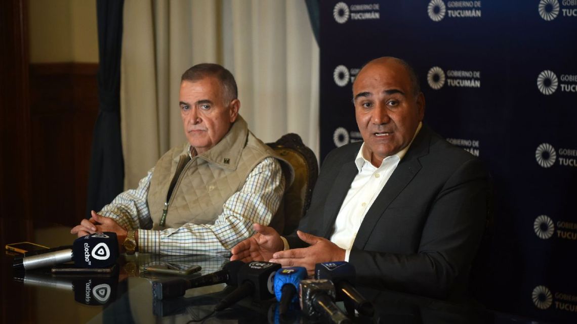 Juan Manzur announces his decision to withdraw his candidacy at a press conference in San Miguel de Tucumán, flanked by gubernatorial candidate Osvaldo Jaldo.