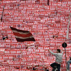 Aficionados del Bayern de Múnich sostienen banderas, bufandas y pancartas mientras animan a su equipo antes del partido de fútbol de la primera división alemana Bundesliga entre el FC Bayern de Múnich y el Schalke 04 en Múnich, sur de Alemania. | Foto:Christof Stache / AFP