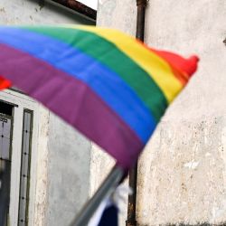 La gente mira desde la ventana la conga del orgullo gay que celebra el día contra la homofobia y la transfobia, en La Habana, Cuba. | Foto:YAMIL LAGE / AFP