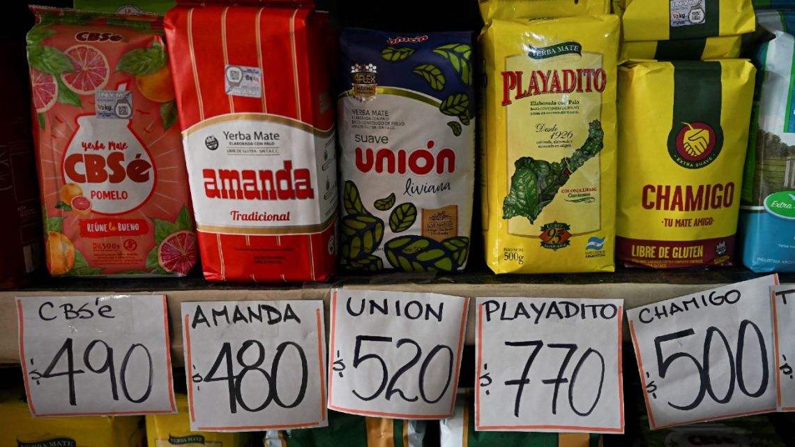 Different brands of yerba mate are seen with signs indicating their prices in pesos at a market in Buenos Aires on May 12, 2023. 