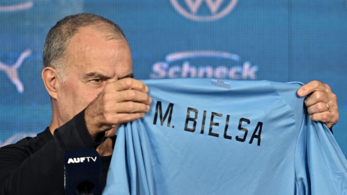 Marcelo Bielsa looks at a shirt of the Uruguayan national football team with his name on it during his presentation as coach of the team, at the Estadio Centenario in Montevideo, on May 17, 2023. 