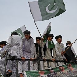 Personas con banderas de Pakistán participan en una concentración para mostrar solidaridad con el ejército de Pakistán en Islamabad, después de que instalaciones militares fueran supuestamente dañadas por partidarios del ex primer ministro de Pakistán Imran Khan tras su detención la semana pasada. | Foto:AAMIR QURESHI / AFP
