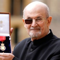 El escritor británico Salman Rushdie posa con su medalla tras ser nombrado Miembro de la Orden de los Compañeros de Honor durante una ceremonia de investidura en el Castillo de Windsor. | Foto:Andrew Matthews / POOL / AFP