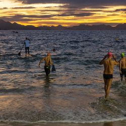 La gente se prepara para nadar en la playa de Copacabana durante el amanecer en Río de Janeiro, Brasil. | Foto:CARL DE SOUZA / AFP