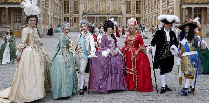 Asistentes disfrazados posan en el patio de Honor antes de participar en la velada de disfraces "Fetes Galantes" en el Castillo de Versalles, a las afueras de París.