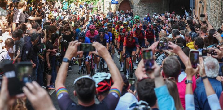 Espectadores animan mientras el pelotón de ciclistas pedalea en la subida de Bérgamo Alta durante la decimoquinta etapa del Giro de Italia 2023, 195 km entre Seregno y Bérgamo.