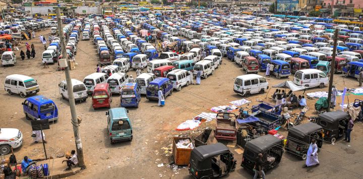 Minibuses y rickshaws motorizados esperan pasajeros en una estación de autobuses de Port Sudan.