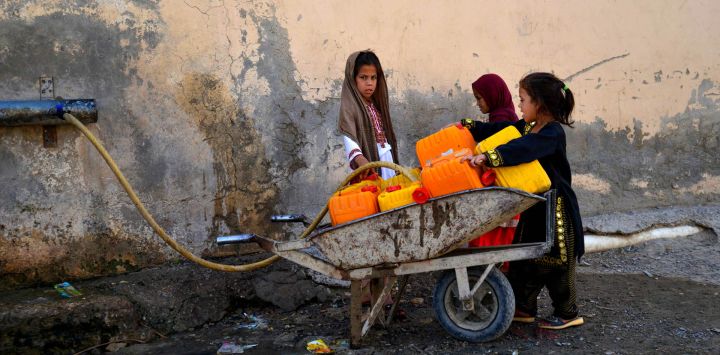 Niñas afganas llenan bidones con agua potable en las afueras de Kandahar.