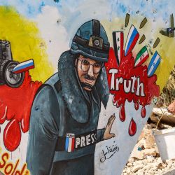 Artistas sirios pintan un mural en la última pared que queda de un edificio derruido que representa al periodista de la AFP Arman Soldin, asesinado en la región de Donbas mientras cubría el conflicto en Ucrania, en Binnish, en la provincia siria de Idlib, controlada por los rebeldes. | Foto:OMAR HAJ KADOUR / AFP