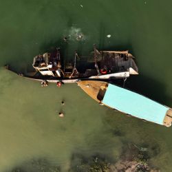 La imagen aérea muestra a personas nadando cerca de embarcaciones en la vía fluvial Shatt al-Arab, formada en la confluencia de los ríos Éufrates y Tigris, en la ciudad de Basora, en el sur de Irak. | Foto:Hussein Faleh / AFP