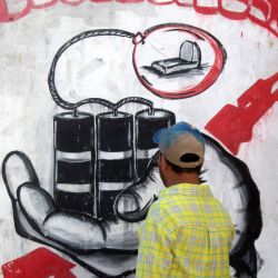 En esta foto el artista callejero yemení Alaa Rubil termina una de sus obras pintadas en una pared de la ciudad portuaria meridional de Adén. Rubil utiliza los edificios llenos de obuses de su ciudad natal como lienzo, pintando imágenes de muerte y desesperación para arrojar luz sobre los horrores y las víctimas de la guerra. | Foto:SALEH Al-OBEIDI / AFP