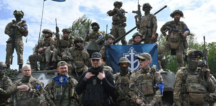 El fundador del Cuerpo de Voluntarios Rusos, Denis, conocido como "Rex Blanco", flanqueado por combatientes vestidos de camuflaje asiste a una presentación para los medios de comunicación en el norte de Ucrania, no lejos de la frontera rusa, en medio de la invasión militar rusa sobre Ucrania.