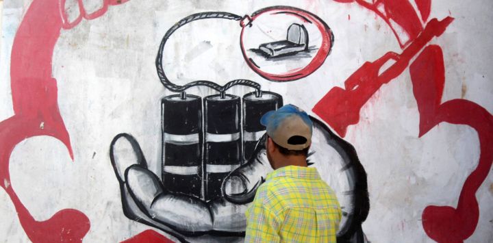 En esta foto el artista callejero yemení Alaa Rubil termina una de sus obras pintadas en una pared de la ciudad portuaria meridional de Adén. Rubil utiliza los edificios llenos de obuses de su ciudad natal como lienzo, pintando imágenes de muerte y desesperación para arrojar luz sobre los horrores y las víctimas de la guerra.