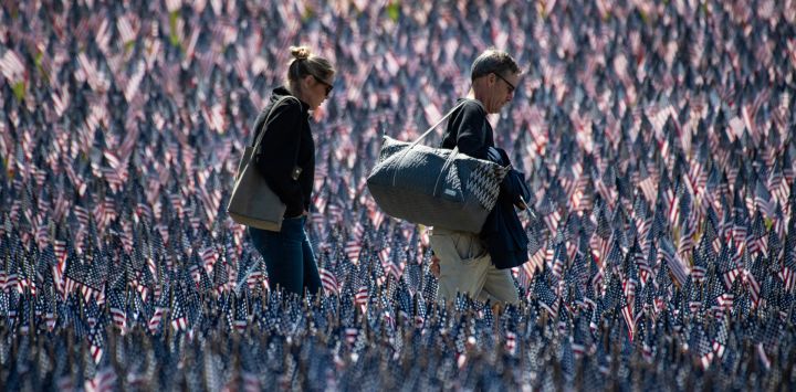 Un grupo de personas recorre un monumento con banderas estadounidenses colocado junto al Monumento a los Soldados y Marineros por el Fondo de Héroes Militares de Massachusetts con motivo del Día de los Caídos, en Boston, Massachusetts.