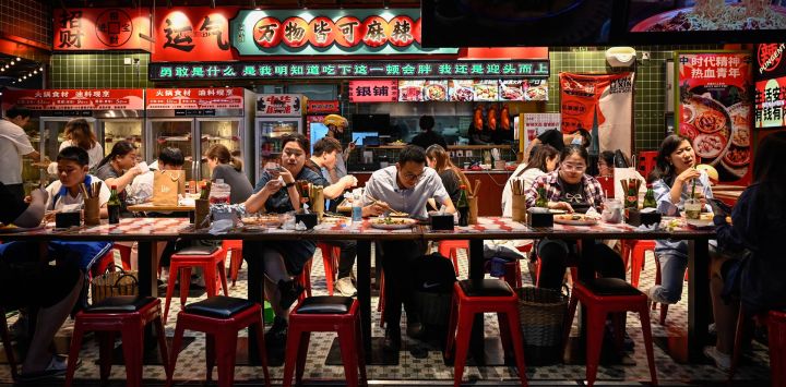 Varias personas cenan en un restaurante de un centro comercial de Pekín, China.