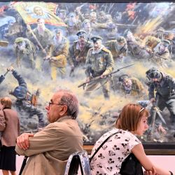 Un grupo de personas visita la exposición del artista patriótico ruso Vasili Nesterenko titulada "Somos rusos, Dios está con nosotros" en Moscú. | Foto:KIRILL KUDRYAVTSEV / AFP