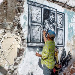 En esta foto el artista callejero yemení Alaa Rubil termina una de sus obras pintadas en una pared de la ciudad portuaria meridional de Adén. Rubil utiliza los edificios llenos de obuses de su ciudad natal como lienzo, pintando imágenes de muerte y desesperación para arrojar luz sobre los horrores y las víctimas de la guerra. | Foto:SALEH Al-OBEIDI / AFP