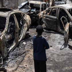 Un niño observa los coches quemados de Matar Ba, jefe de gabinete del presidente de Senegal, Macky Sall, en Dakar, Senegal. Las protestas estallaron en los alrededores de Dakar por la detención del líder de la oposición senegalesa Ousmane Sonko antes del veredicto final en su proceso por violación. | Foto:JOHN WESSELS / AFP