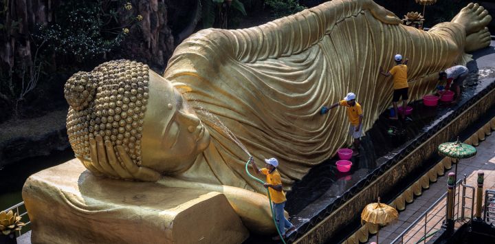 Trabajadores limpian una estatua de Buda en el templo de Maha Vihara Mojopahit, en Mojokerto, Indonesia, antes del festival de Vesak, que conmemora el nacimiento, la iluminación y la muerte de Buda.