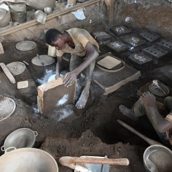 Personas fabrican ollas en un taller de Abobo, un suburbio de Abiyán, Costa de Marfil. | Foto:Issouf Sanogo / AFP