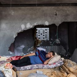 Un palestino duerme en su casa gravemente dañada durante los combates entre Israel y militantes de la Yihad Islámica, en Beit Lahia, en el norte de la Franja de Gaza. | Foto:MOHAMMED ABED / AFP