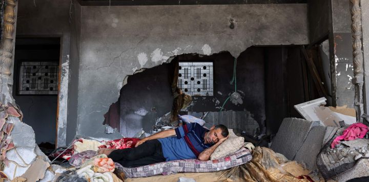 Un palestino duerme en su casa gravemente dañada durante los combates entre Israel y militantes de la Yihad Islámica, en Beit Lahia, en el norte de la Franja de Gaza.