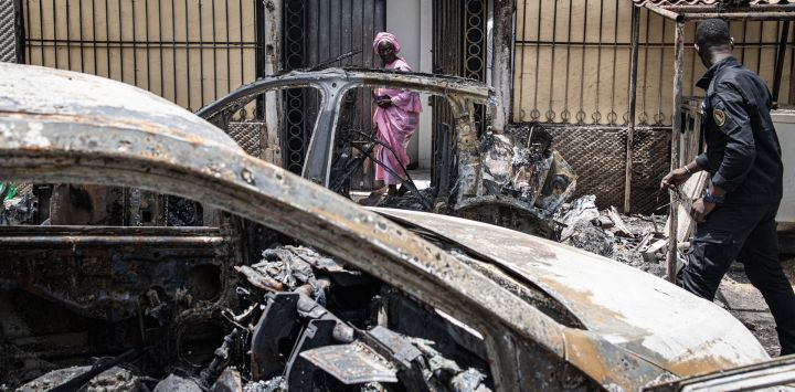Una mujer sale de la casa incendiada de Matar Ba, jefe de gabinete del presidente de Senegal, Macky Sall, en Dakar, Senegal.
