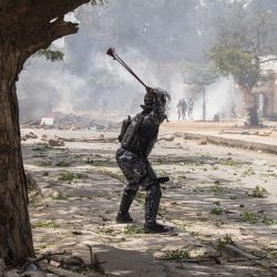 Un policía dispara un tirachinas contra manifestantes en Dakar, durante una protesta. Un tribunal de Senegal condenó al líder de la oposición Ousmane Sonko, candidato a las elecciones presidenciales de 2024, a dos años de prisión acusado de "corromper a la juventud", pero lo absolvió de violación y de proferir amenazas de muerte. | Foto:JOHN WESSELS / AFP