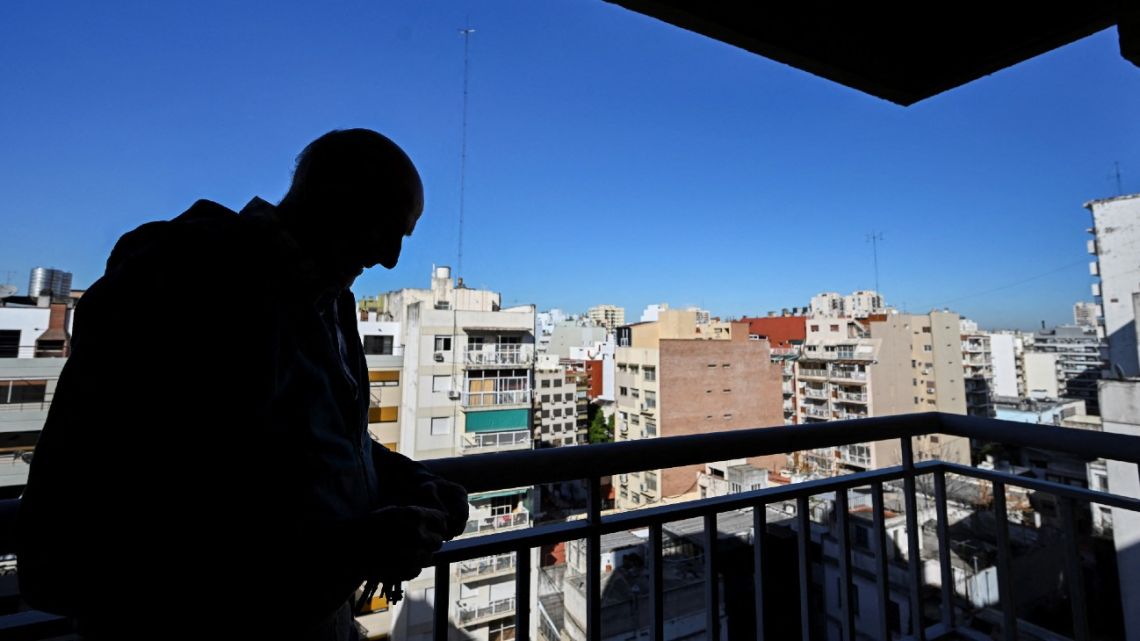 Germán Matienzo, apartment owner, rests on the balcony of his empty property in Buenos Aires on May 16, 2023. 