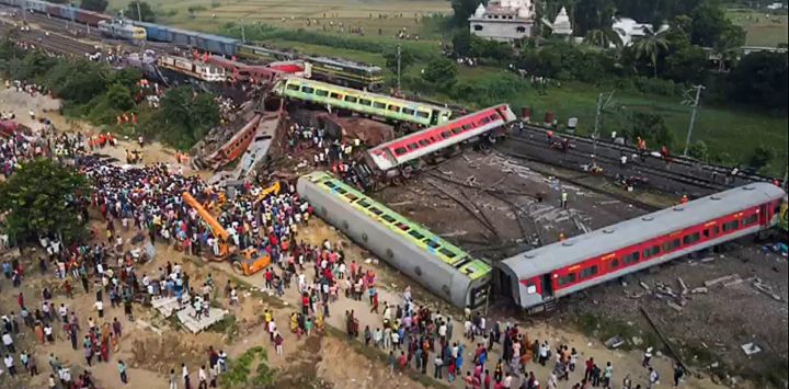 Esta imagen muestra a personas reunidas en el lugar del accidente de un choque de tres trenes cerca de Balasore, a unos 200 km (125 millas) de la capital del estado, Bhubaneswar, en el estado oriental de Odisha.