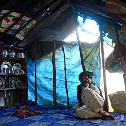 Un nómada cachemir habla por teléfono móvil mientras descansa en el interior de una tienda improvisada a las afueras de Srinagar, India. | Foto:TAUSEEF MUSTAFA / AFP