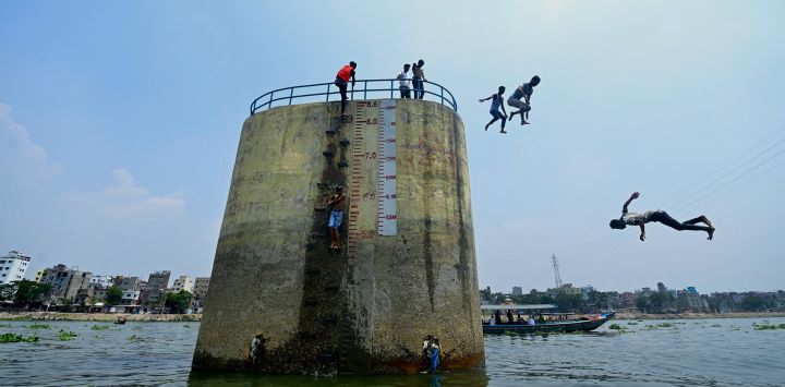 Jóvenes saltan desde un pilar al río Buriganga en Dhaka, Bangladesh.