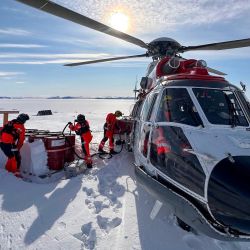 Un helicóptero de rescate Super Puma reposta en el fiordo Rijpfjord, al norte de Svalbard, en ruta hacia el buque científico ruso Severny Polyus, atrapado en el hielo ártico a unos 440 km al sur del polo norte. | Foto:Sysselmesteren Svalbard / AFP