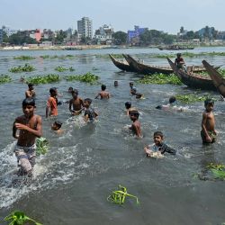 Unos niños se refrescan en el río Buriganga, en Dhaka, Bangladesh. | Foto:MUNIR UZ ZAMAN / AFP