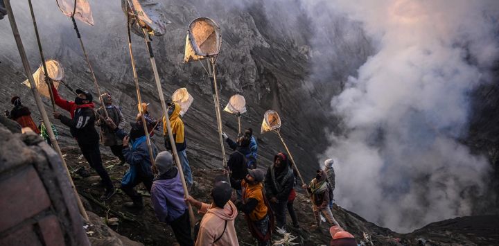 Los aldeanos utilizan redes para recoger las ofrendas lanzadas por los miembros del grupo subétnico Tengger en el cráter del volcán activo del monte Bromo como parte del festival Yadnya Kasada en Probolinggo, provincia de Java Oriental, Indonesia.