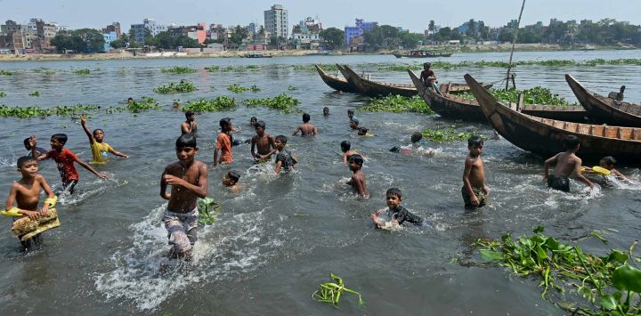 Unos niños se refrescan en el río Buriganga, en Dhaka, Bangladesh.