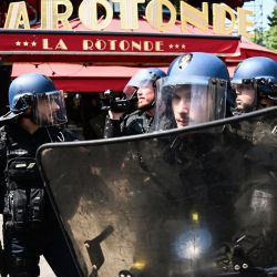 Gendarmes franceses frente al restaurante La Rotonde durante una manifestación después de que el gobierno impulsara una reforma de las pensiones a través del parlamento sin votación, utilizando el artículo 49.3 de la constitución, en París. | Foto:CHRISTOPHE ARCHAMBAULT / AFP
