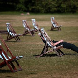 Personas sentadas en reposeras sobre hierba seca de color marrón, bajo el sol en Hyde Park, en el centro de Londres. | Foto:HENRY NICHOLLS / AFP